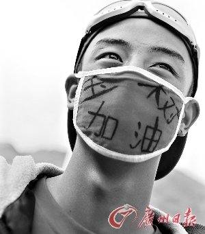 一名乐观的藏族男孩戴着写有“玉树加油”字样的口罩。 新华社发