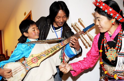 2月17日，加措在爸爸扎西旺拉、妈妈达娃的指导下学习弹唱六弦琴。 西藏拉孜县小学四年级学生加措与父母及四十多名农民叔叔阿姨一起来到拉萨，参加2009年西藏电视台藏历土牛新年《雪域欢歌》大型晚会表演。小加措是“堆谐”（西藏日喀则西部地区的民间弹唱舞蹈艺术）表演队年龄最小的演员，他爸爸扎西旺拉是小学音乐老师，也是此次“堆谐”表演队的指导老师。小加措6岁开始在课余时间跟爸爸学“堆谐”，现在跳得很熟练，妈妈达娃也是拉孜县农民“堆谐”表演队的演员。 新华社记者 索朗罗布 摄