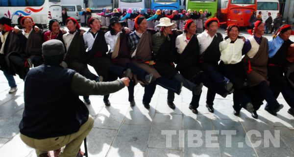 排练场地虽然只是一个停车场，但是演员们练起来可不含糊，编导在前方督阵。