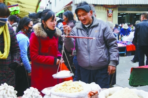 在年货一条街，市民正在购买奶渣