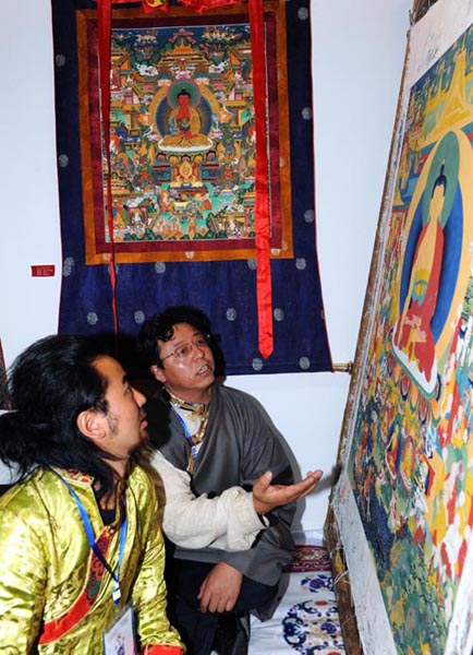 8月6日，西藏拉姆拉绰艺苑画师丁嘎（右）和一级唐卡画师顿珠在西藏博物馆交流唐卡绘画经验。